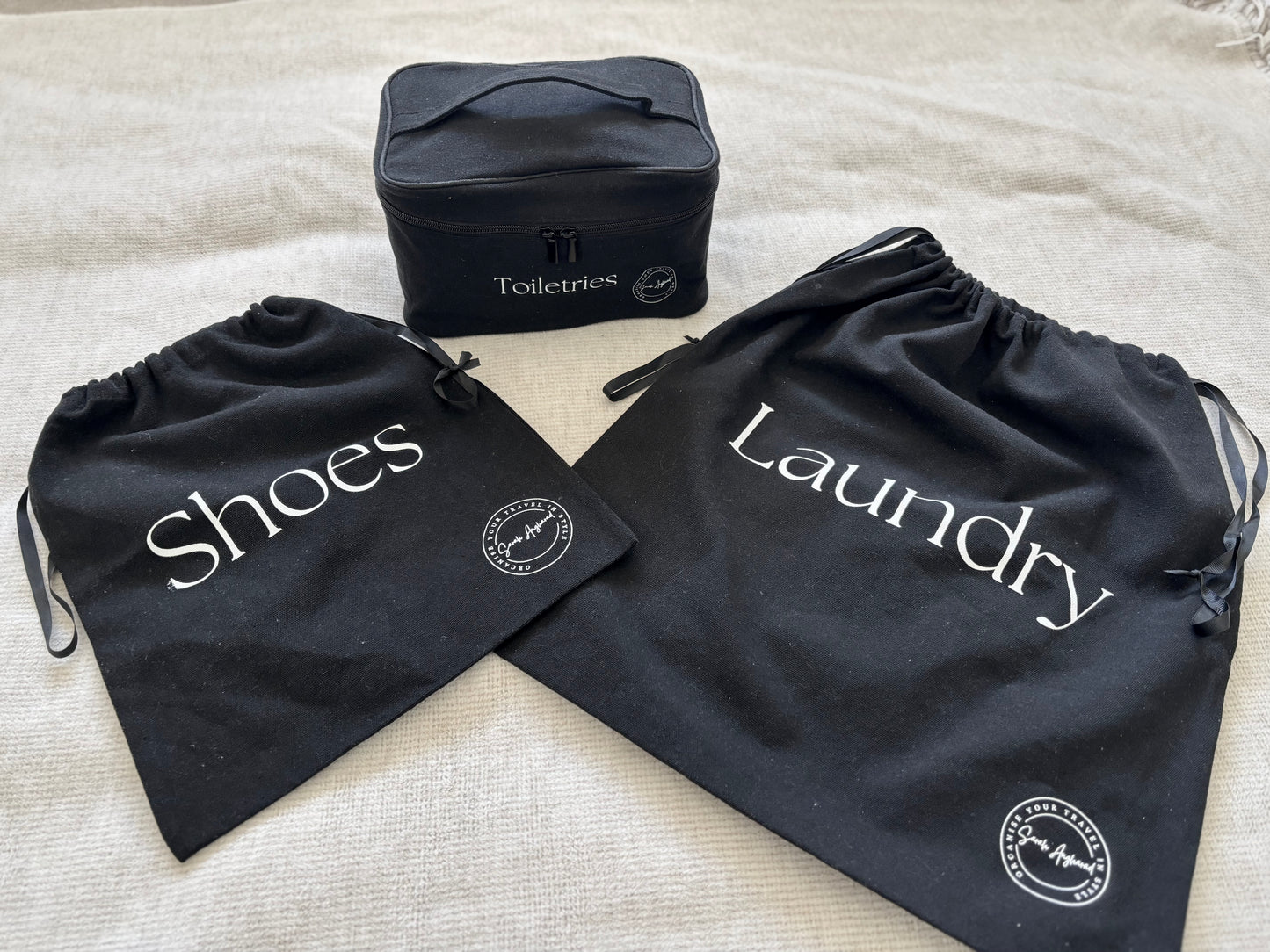 3 black bags, one laundry bag, one shoes bag and one toiletries bag