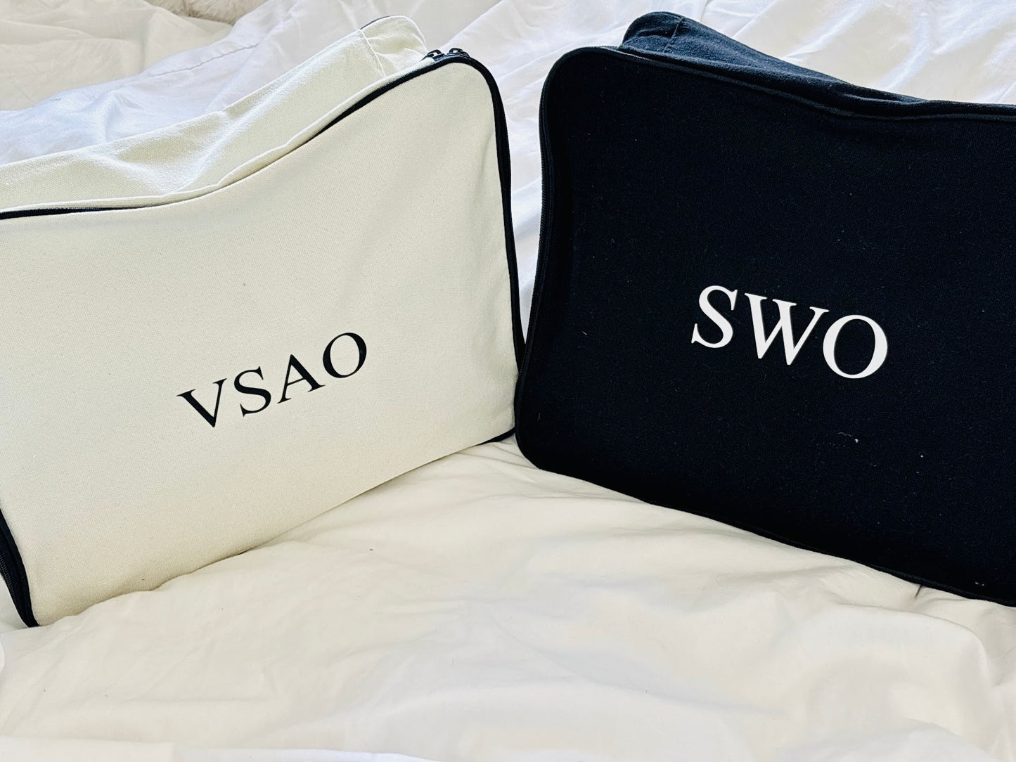 One cream and one black personalised packing cube
