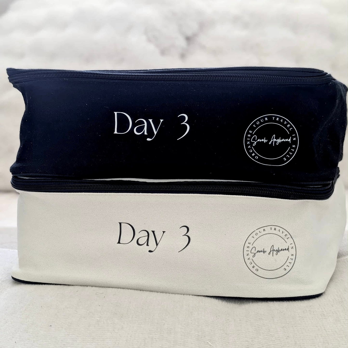 Two travel bags, one black and one white, with 'Day 3' text on a light background.
