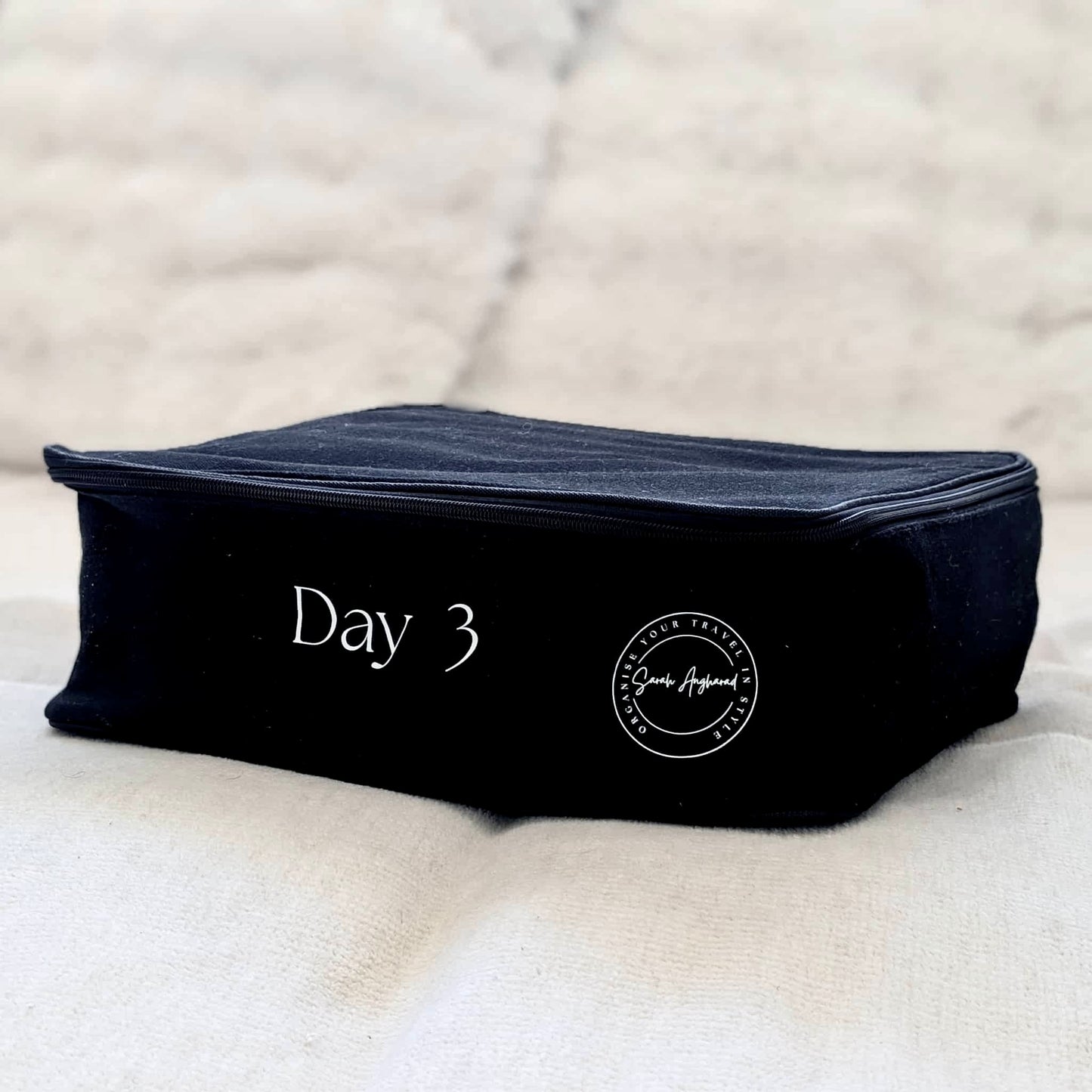 Black daily travel pouch with 'Day 3' text on a textured surface