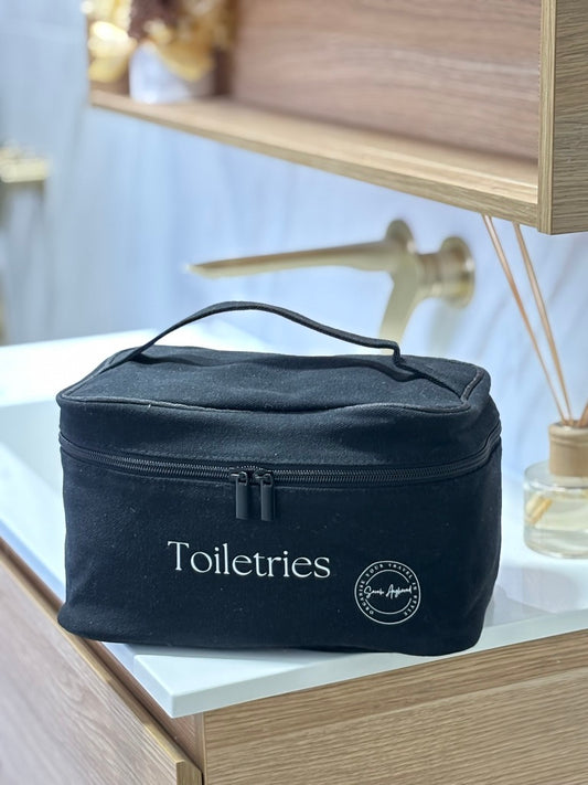 Black cotton canvas toiletry bag with zipper, perfect for travel essentials.