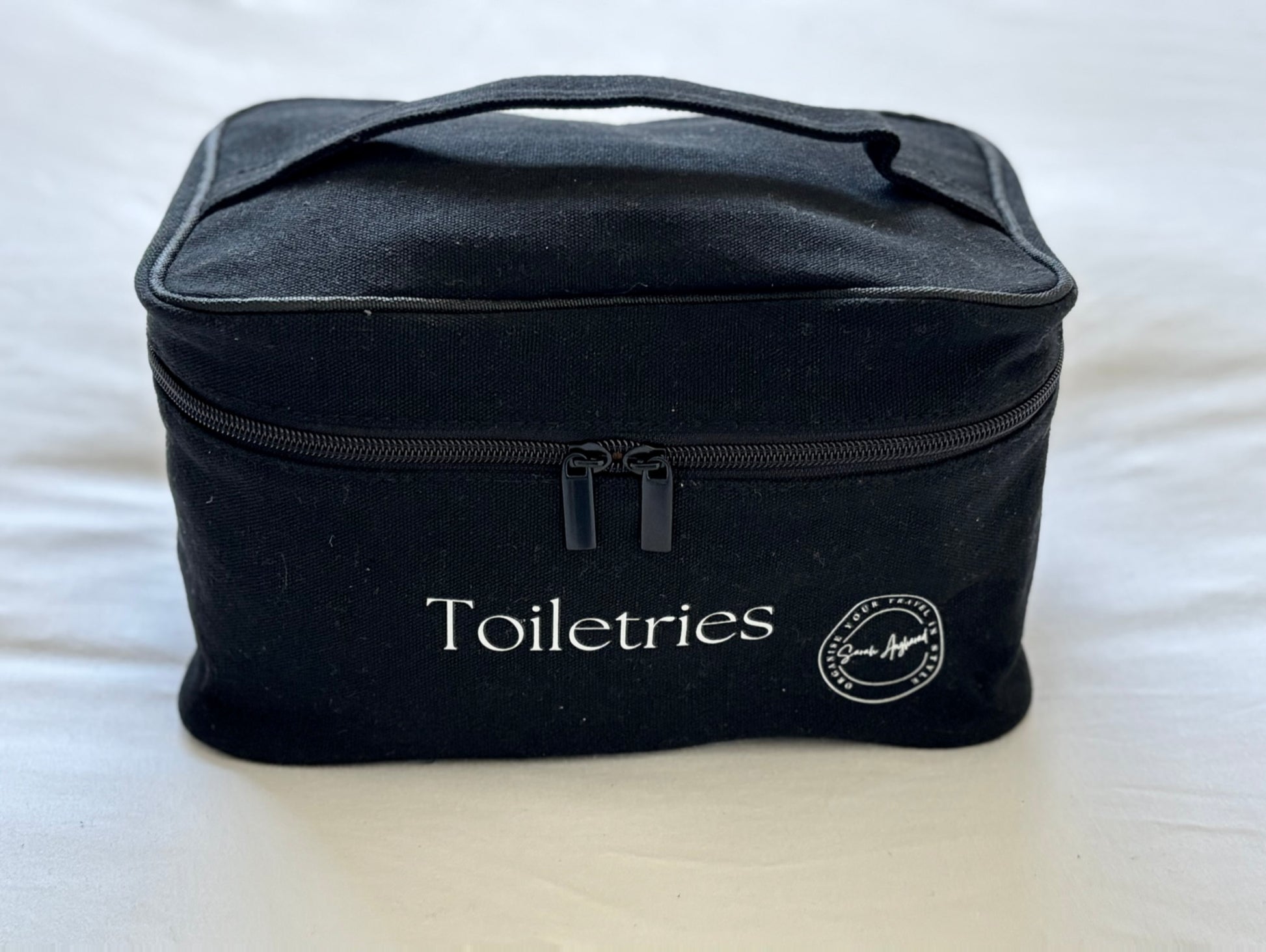 Black toiletries bag with 'Toiletries' text on a white background
