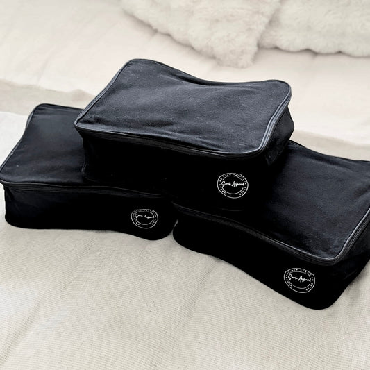 Set of 3 black packing cubes with a logo on a light background